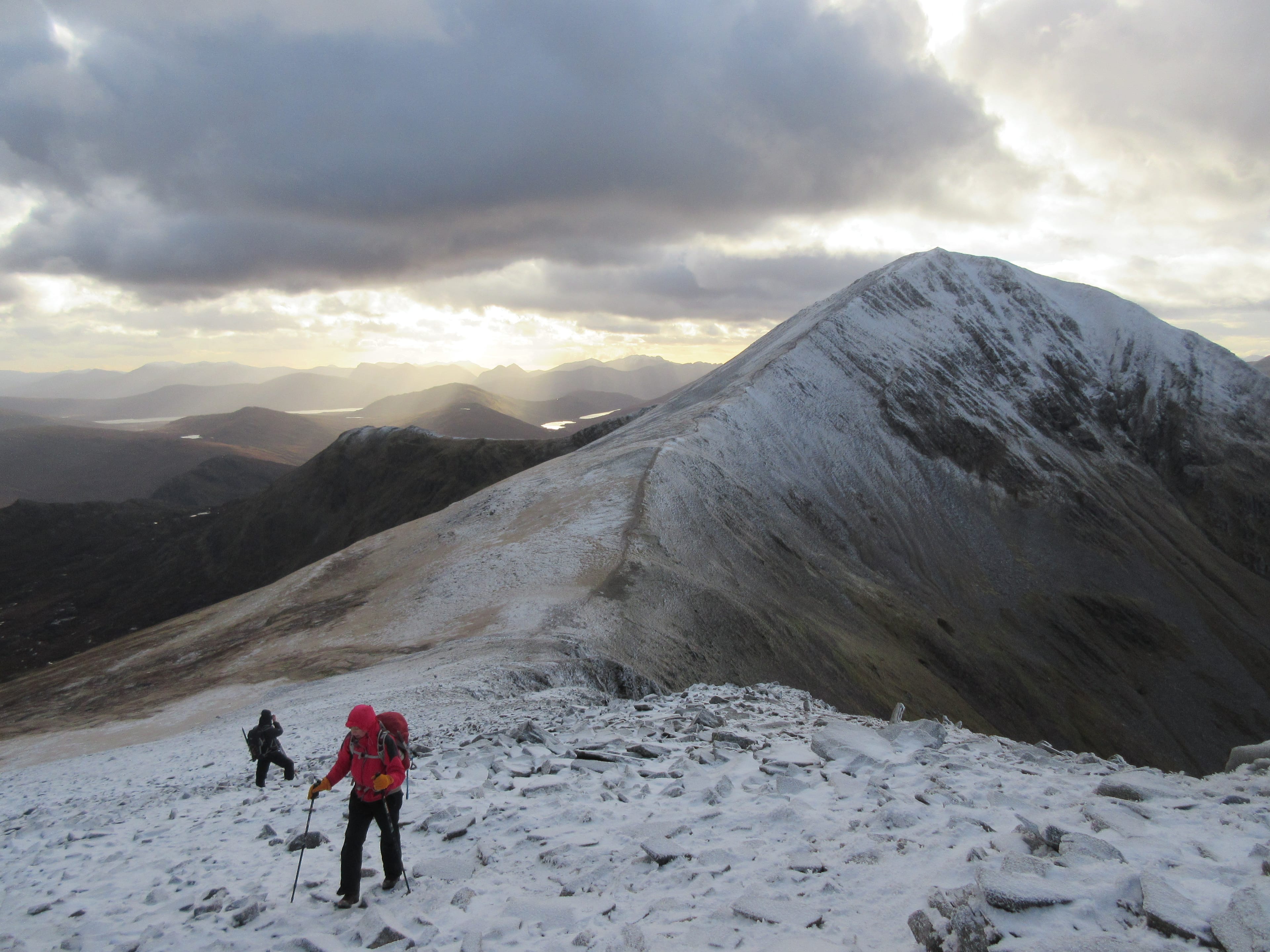 WINTER HORIZON: Heading back from Stob Core Easain in snowy conditions with shafts of light illuminating distant hills