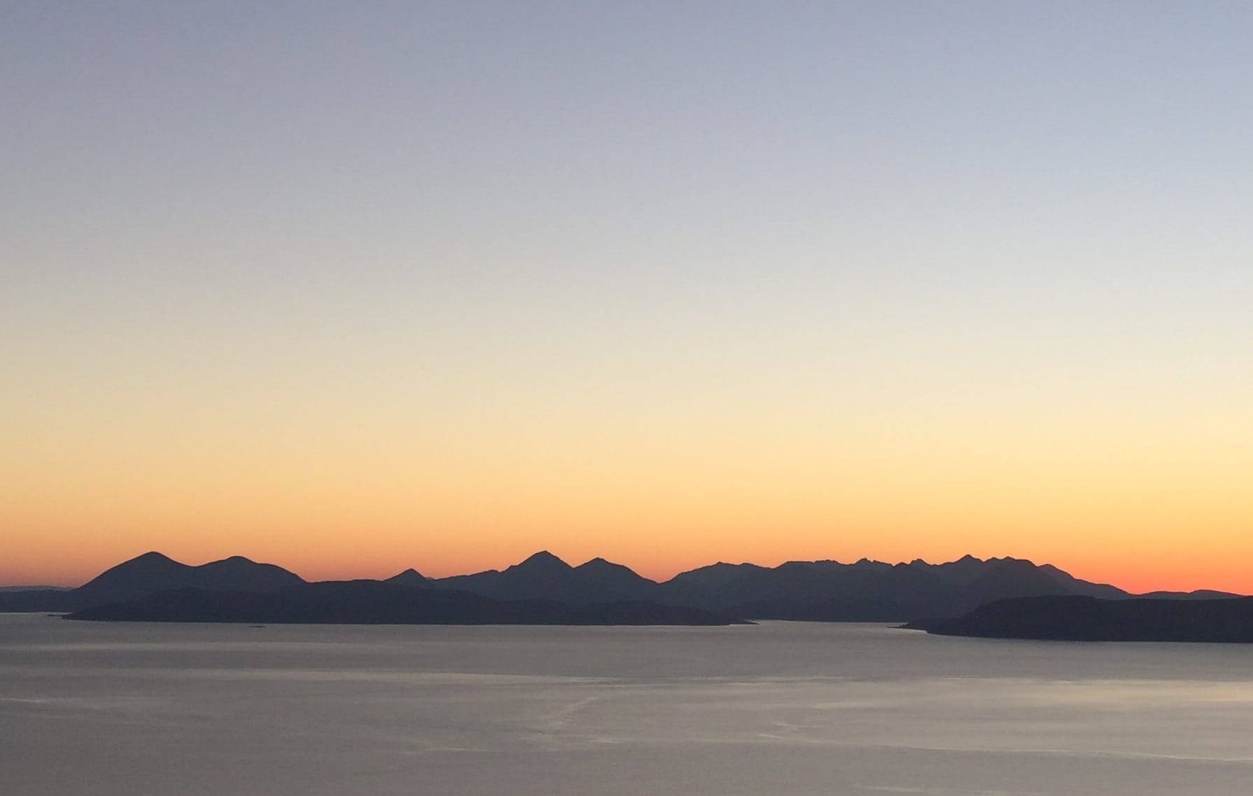 GUIDING LIGHT: The peaks of Skye backlit by the setting sun during the descent of Beinn a' Chlachain in Applecross