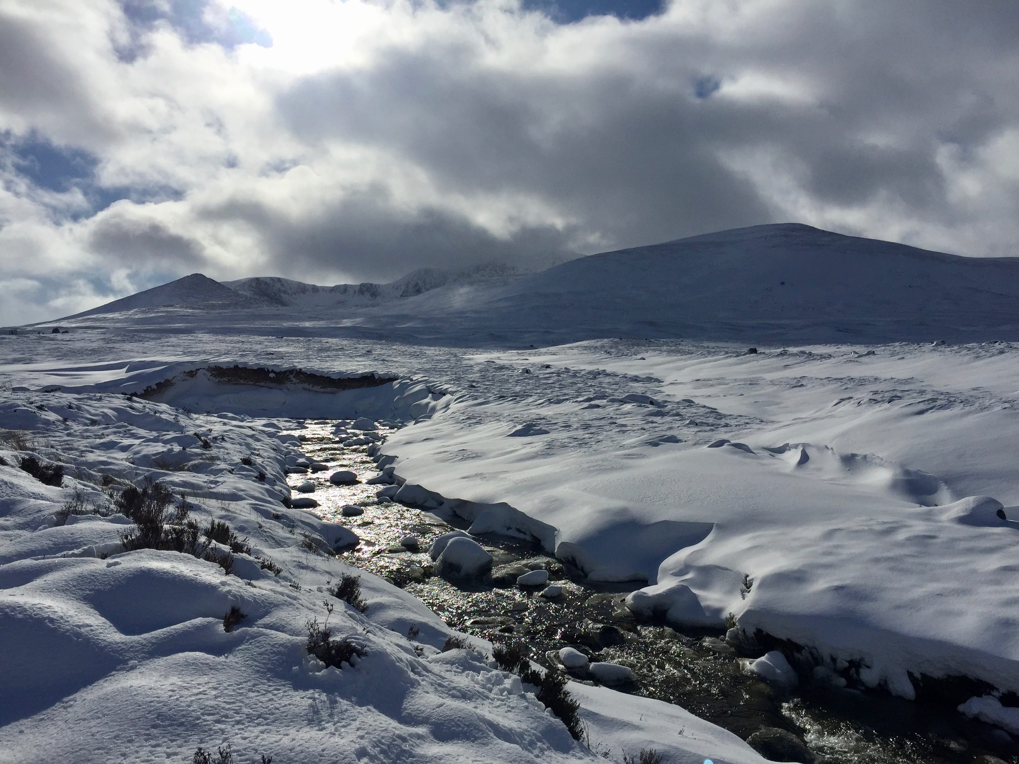 BROAD WHITE CANVAS: The distant shape of Lochnagar looms out of the snowy landscape as the running waters sparkle in the light
