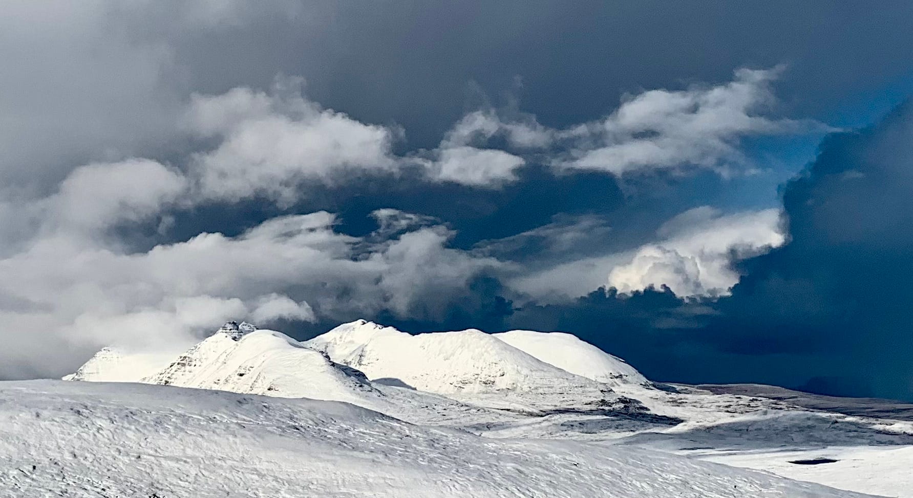 BLACK AND WHITE: Threatening skies and towering clouds growing darker by the minute over the brilliant white spires of An Teallach